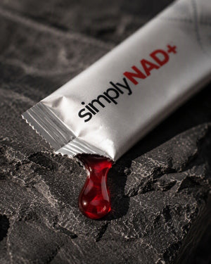 simplyNAD+ liquid NAD+ shot — berry liquid pouring from the packet